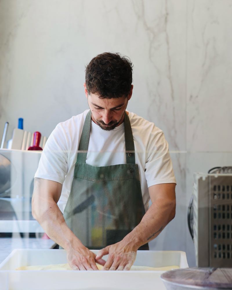 Le pizzaiolo travaille la pâte à la main
